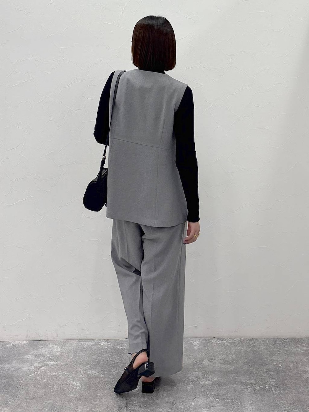 ブラック系のニット/セーター、グレー系のその他パンツ、グレー系のベストを着用したレディースの冬コーディネートの6枚目の写真