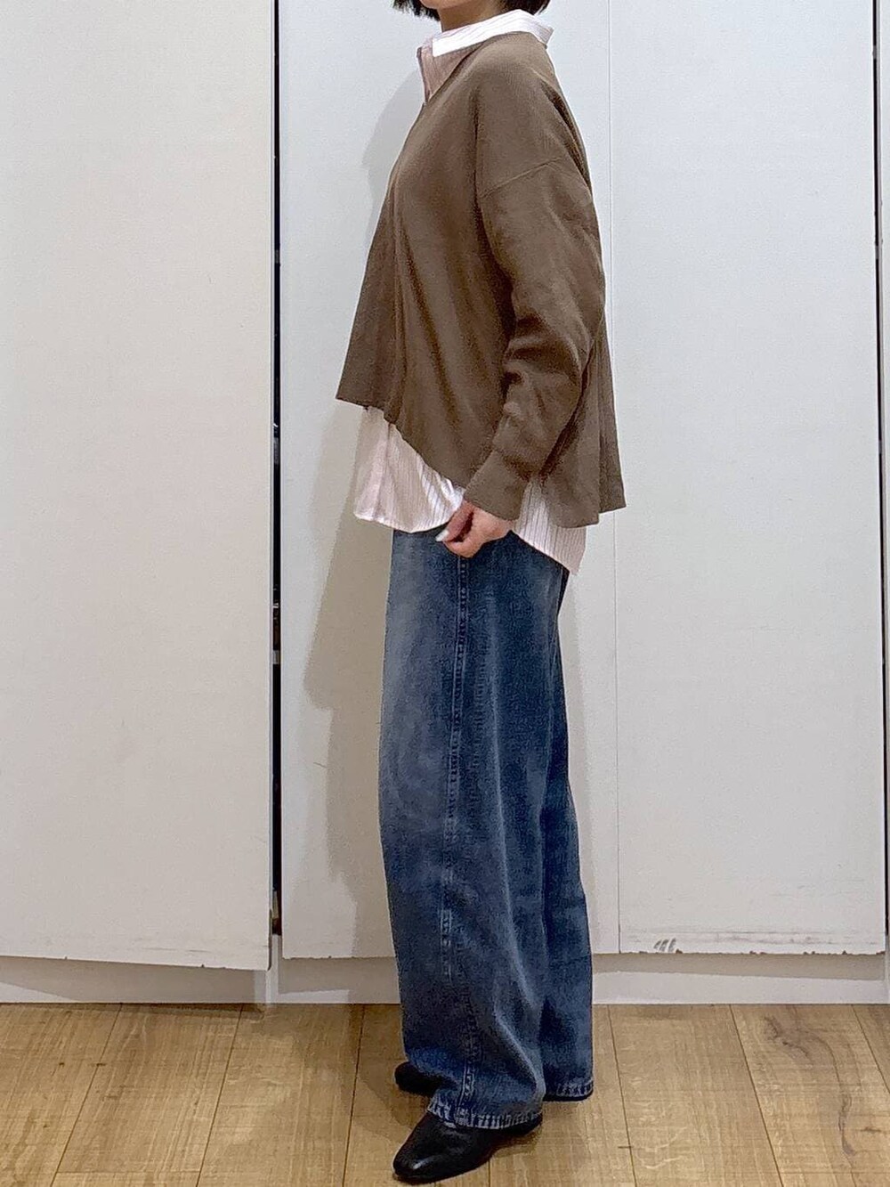 ピンク系のシャツ/ブラウス、ブラック系のブーツ、ブルー系のデニムパンツを着用したレディースの冬コーディネートの4枚目の写真