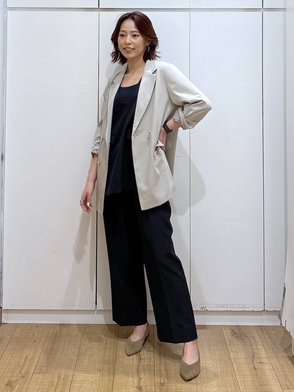 ベージュ系のパンプス、ベージュ系のテーラードジャケット、ブラック系のセットアップを着用したレディースの春コーディネートの2枚目の写真