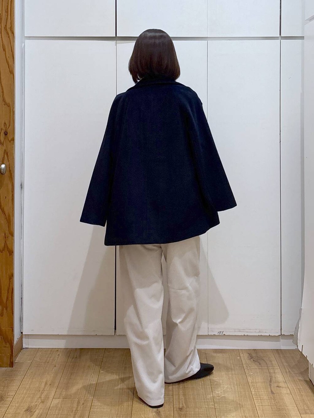 ブルー系のチェスターコート、ベージュ系のスウェット、グレー系のその他パンツを着用したレディースの秋コーディネートの6枚目の写真