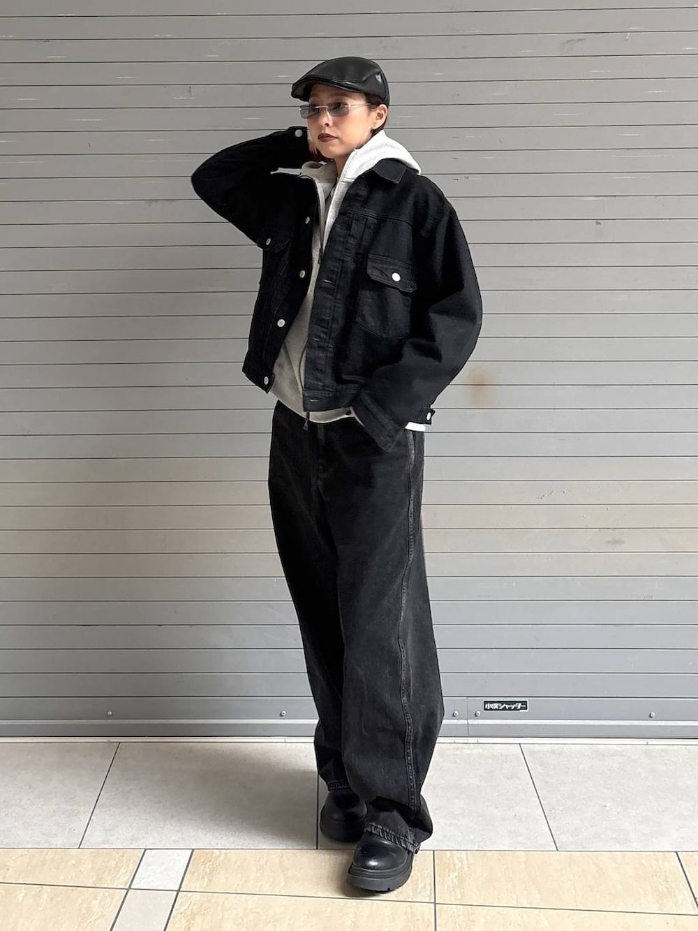 ブラック系のデニムパンツ、ブラック系のデニムジャケット、グレー系のパーカーを着用したレディースの冬コーディネートの9枚目の写真