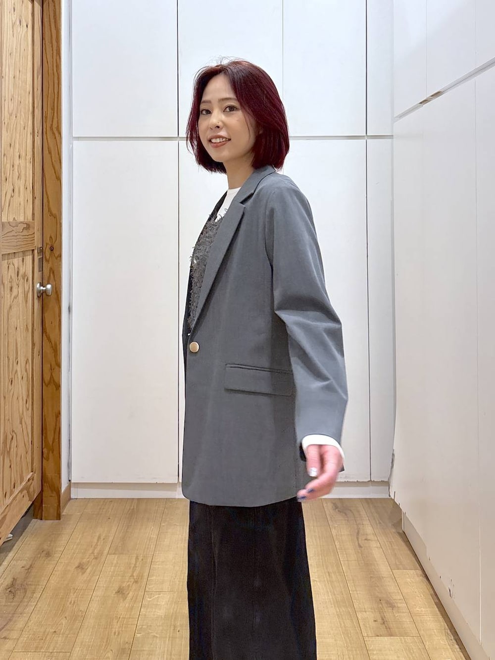 グレー系のテーラードジャケット、ブラック系のブーツ、ブラック系のデニムパンツを着用したレディースの春コーディネートの8枚目の写真