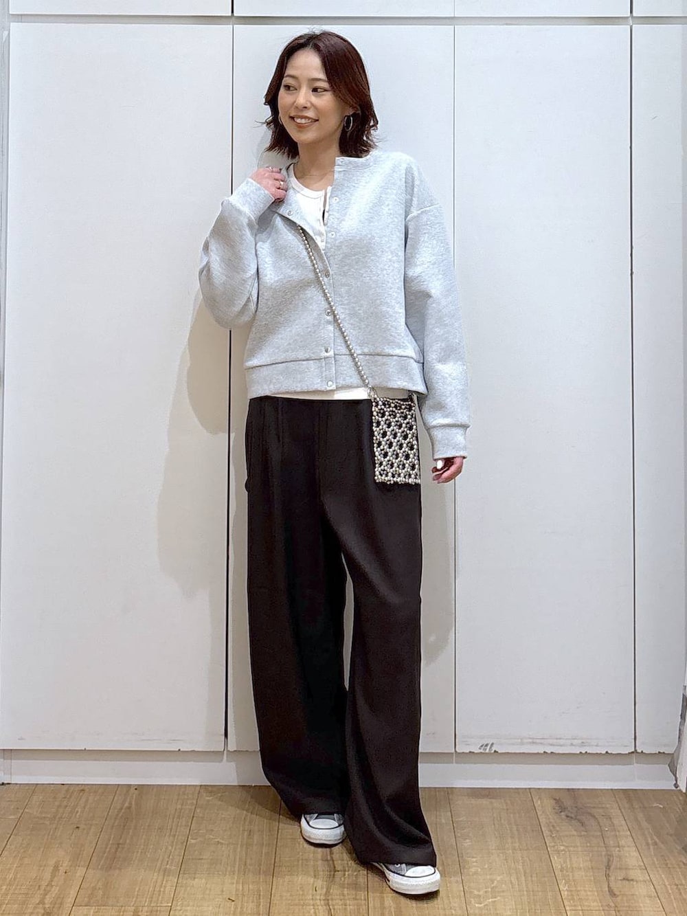 グレー系のカーディガン/ボレロ、ブラウン系のその他パンツ、ホワイト系のタンクトップを着用したレディースの春コーディネートの6枚目の写真