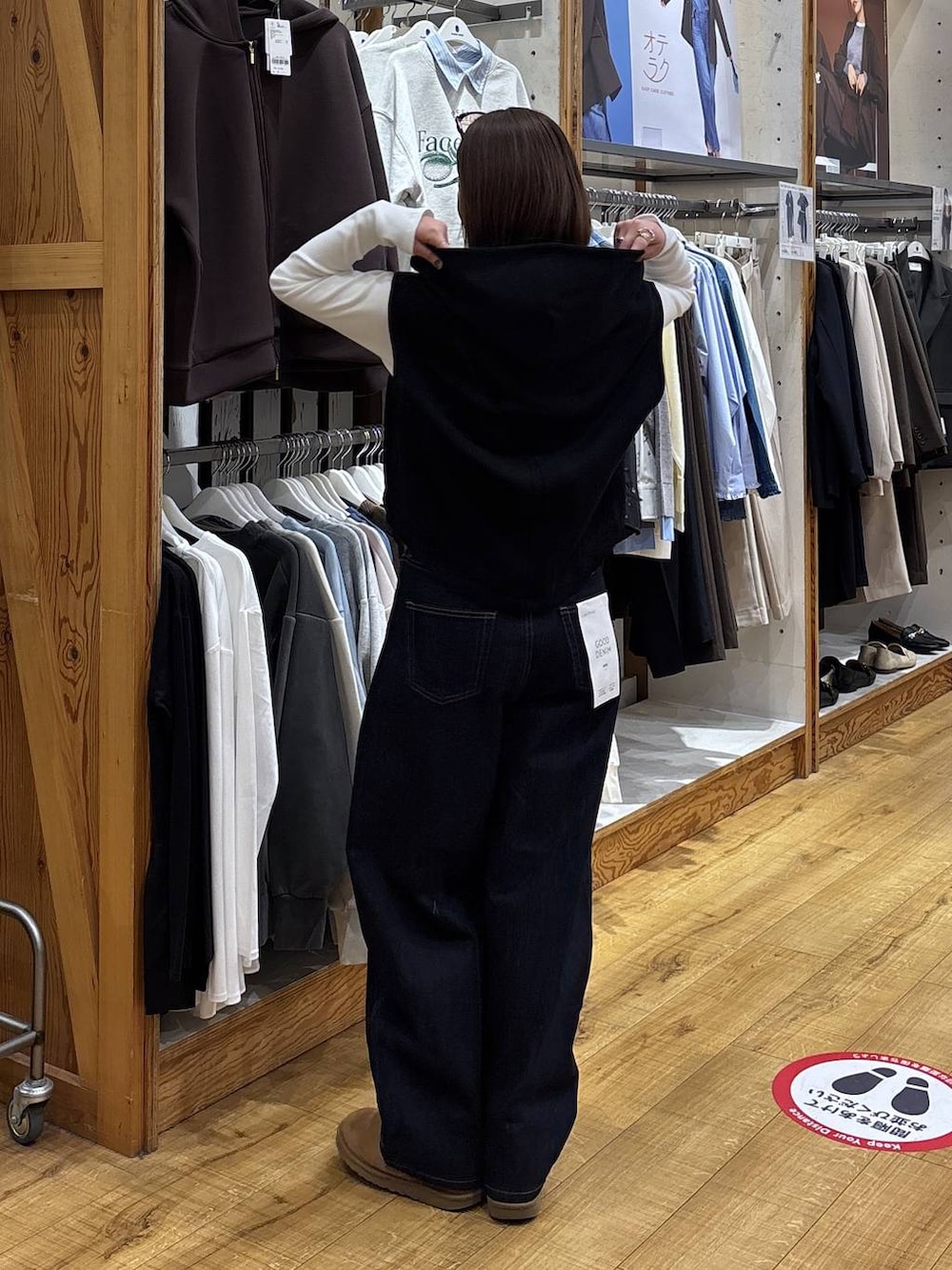 ブルー系のデニムパンツ、ブラック系のベストを着用したレディースの冬コーディネートの5枚目の写真