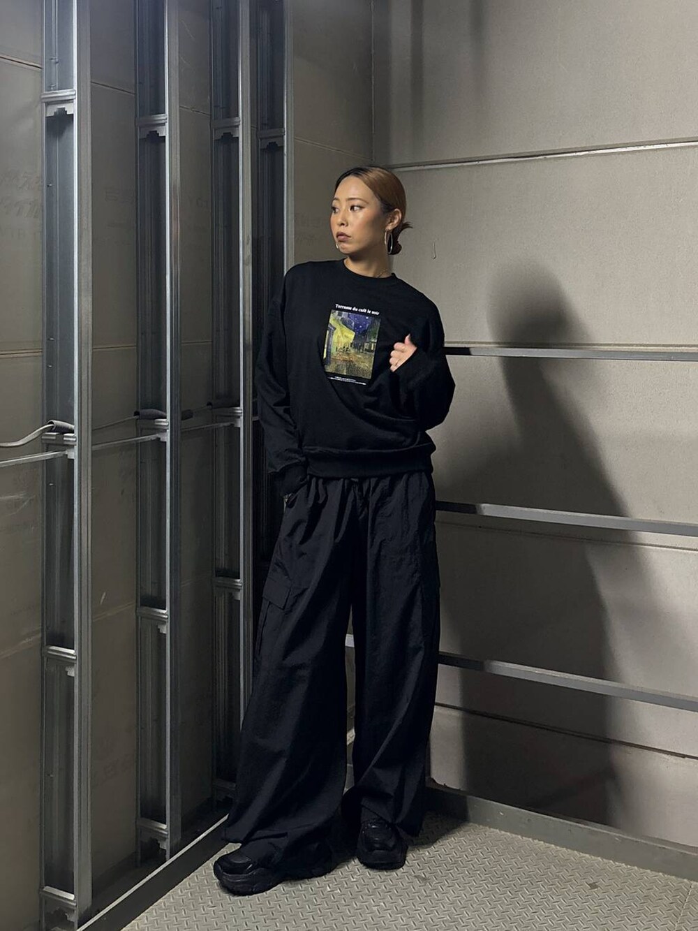ブラック系のスニーカー、ブラック系のTシャツ/カットソーを着用したレディースの秋コーディネートの2枚目の写真