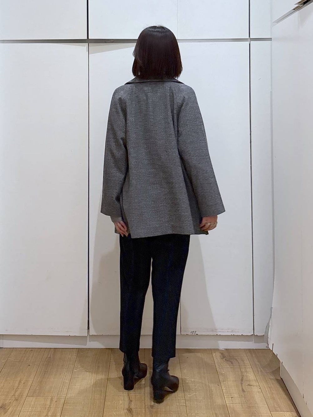 グレー系のチェスターコート、ブラック系のその他パンツ、ブラック系のその他シューズを着用したレディースの秋コーディネートの2枚目の写真