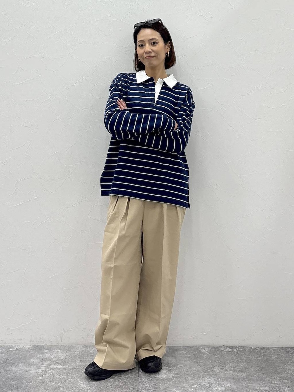 ブラック系のスニーカー、ベージュ系のチノパンツ、グリーン系のスウェットを着用したレディースの冬コーディネートの2枚目の写真