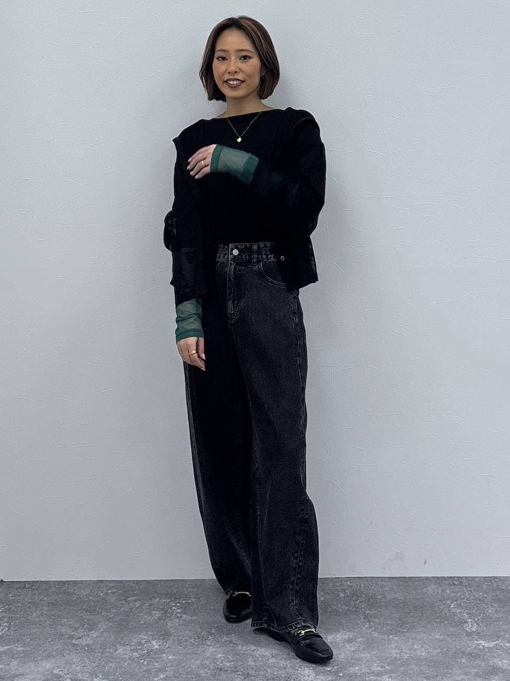 ブラック系のローファー、ブラック系のパーカー、ゴールド系のネックレスを着用したレディースの春コーディネートの2枚目の写真