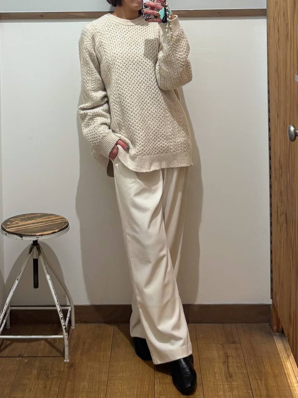 ホワイト系のニット/セーター、グレー系のその他パンツ、ブラック系のブーツを着用したレディースの冬コーディネートの2枚目の写真