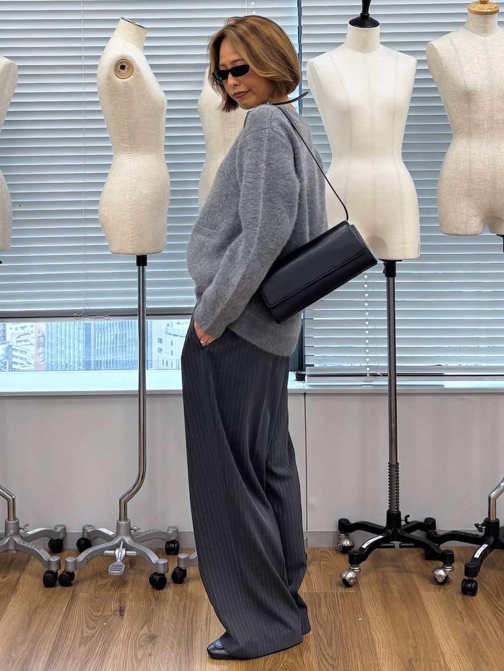 グレー系のその他パンツ、ブラック系のショルダーバッグ、ブラック系のローファーを着用したレディースの秋コーディネートの4枚目の写真