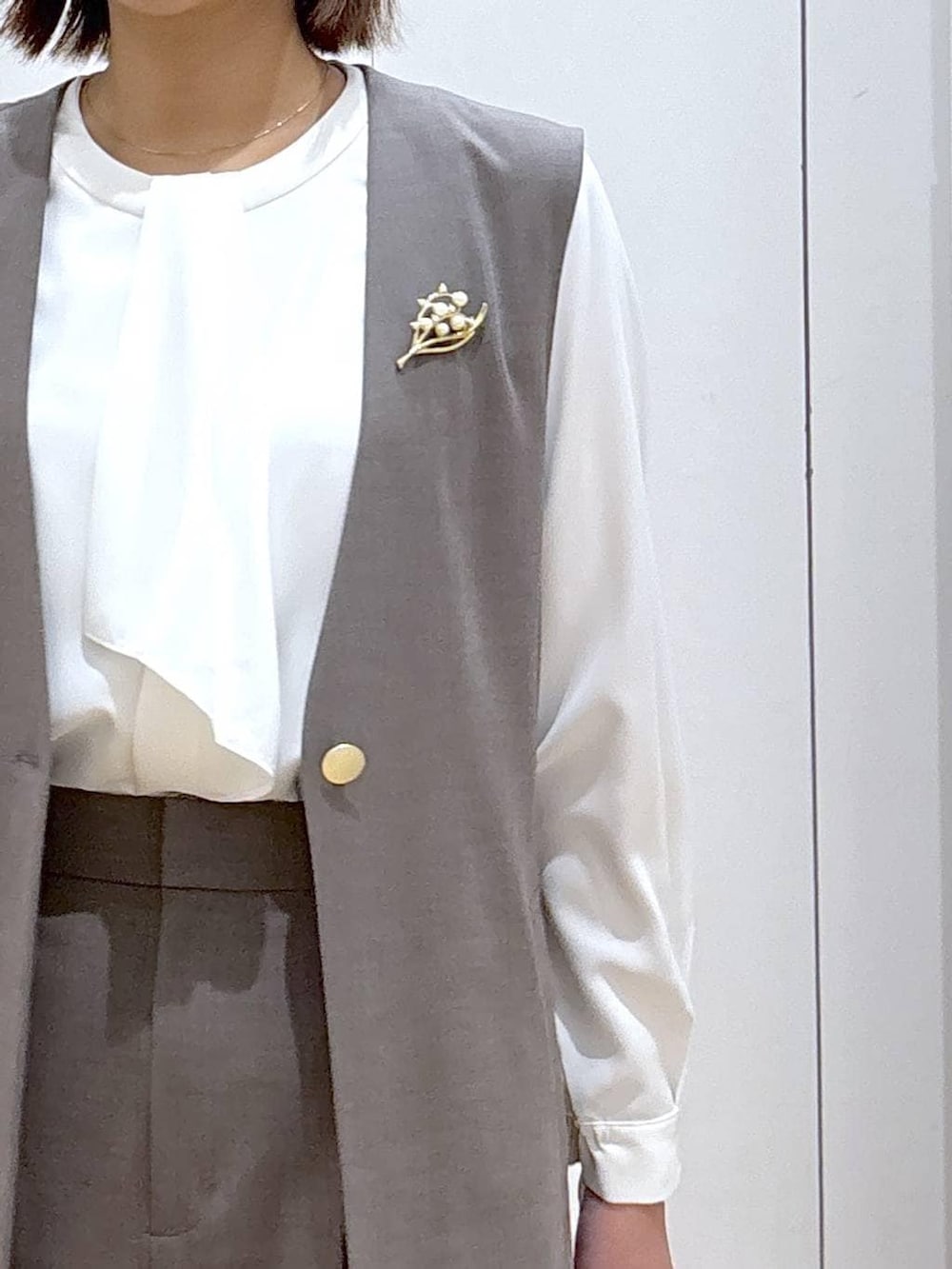 ブラウン系のスラックス、ホワイト系のシャツ/ブラウス、ブラウン系のその他アウターを着用したレディースの冬コーディネートの8枚目の写真