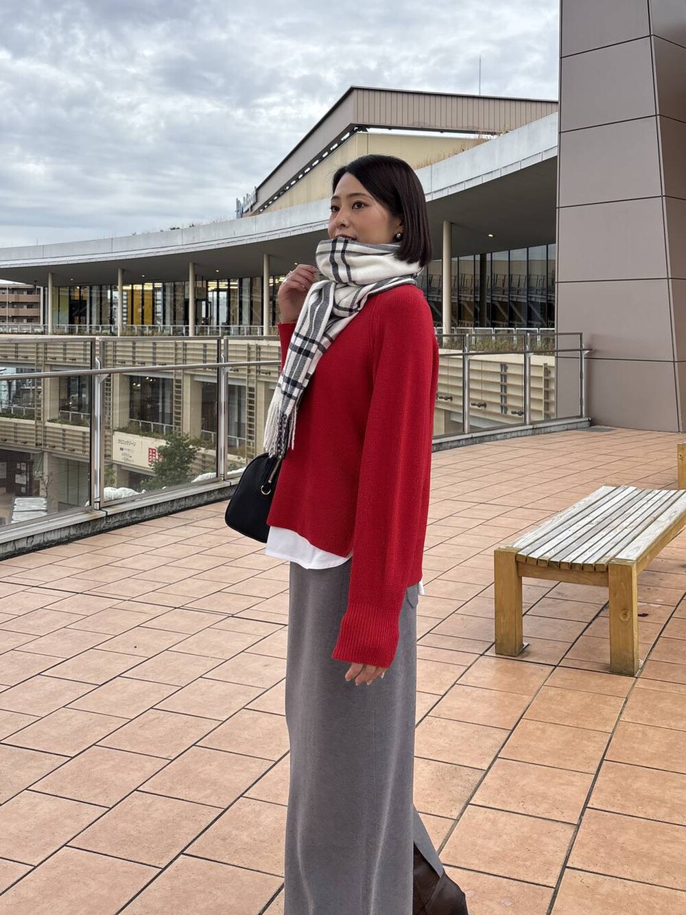 ブラウン系のチェスターコート、グレー系のスカート、ホワイト系のTシャツ/カットソーを着用したレディースの秋コーディネートの7枚目の写真