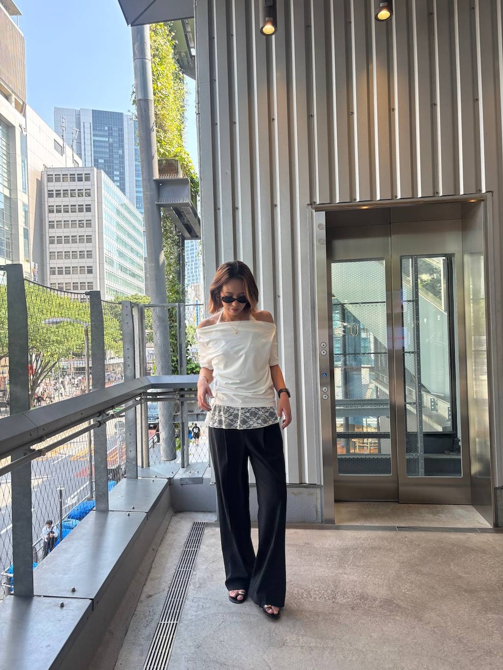 ブラック系のその他パンツ、ブラック系のサンダル、ホワイト系のTシャツ/カットソーを着用したレディースの春コーディネートの9枚目の写真