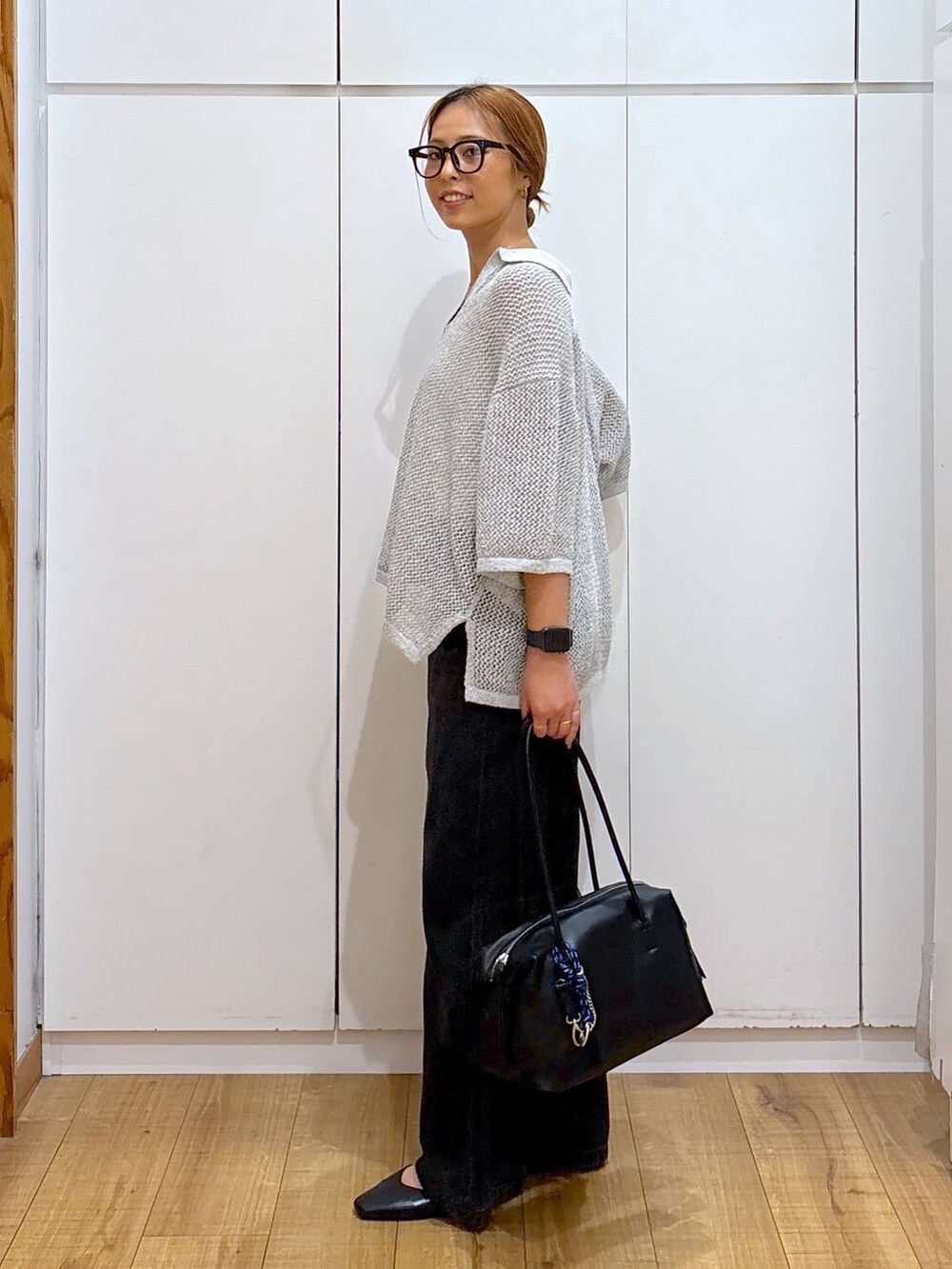 ブラック系のパンプス、ホワイト系のキャミソール、ブラック系のボストンバッグを着用したレディースの秋コーディネートの3枚目の写真