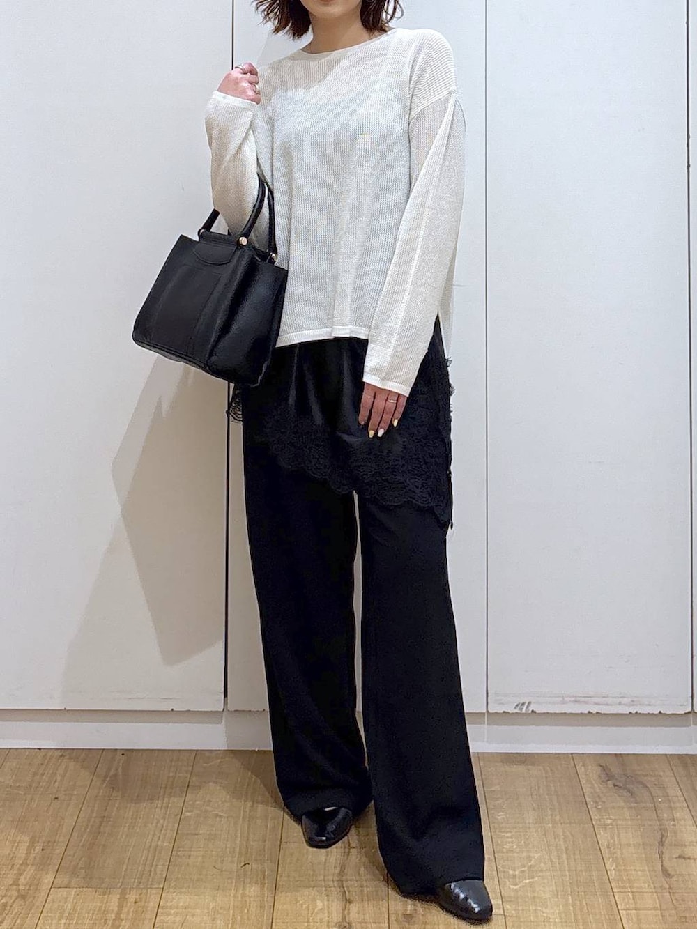 ブラック系のパンプス、ブラック系のトートバッグ、ブラック系のキャミソールを着用したレディースの春コーディネートの3枚目の写真