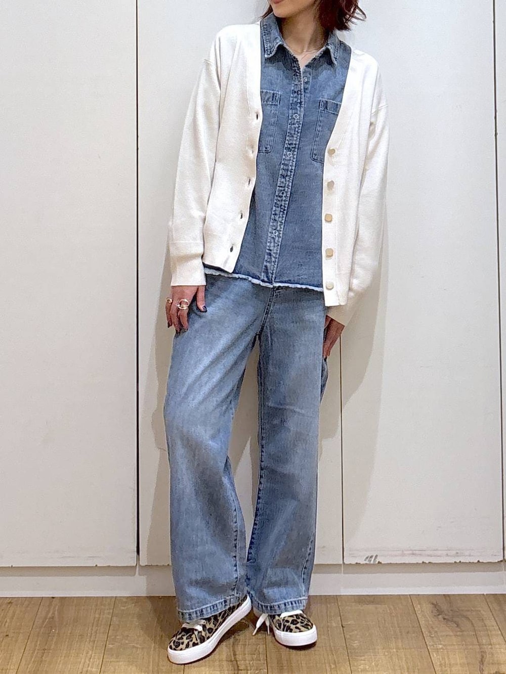 ブルー系のデニムパンツ、ベージュ系のカーディガン/ボレロ、ブルー系のシャツ/ブラウスを着用したレディースの春コーディネートの2枚目の写真