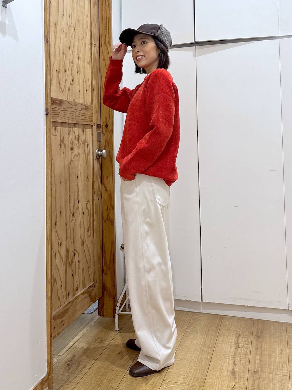 グレー系のその他パンツ、ブラウン系のブーツ、レッド系のニット/セーターを着用したレディースの冬コーディネートの4枚目の写真