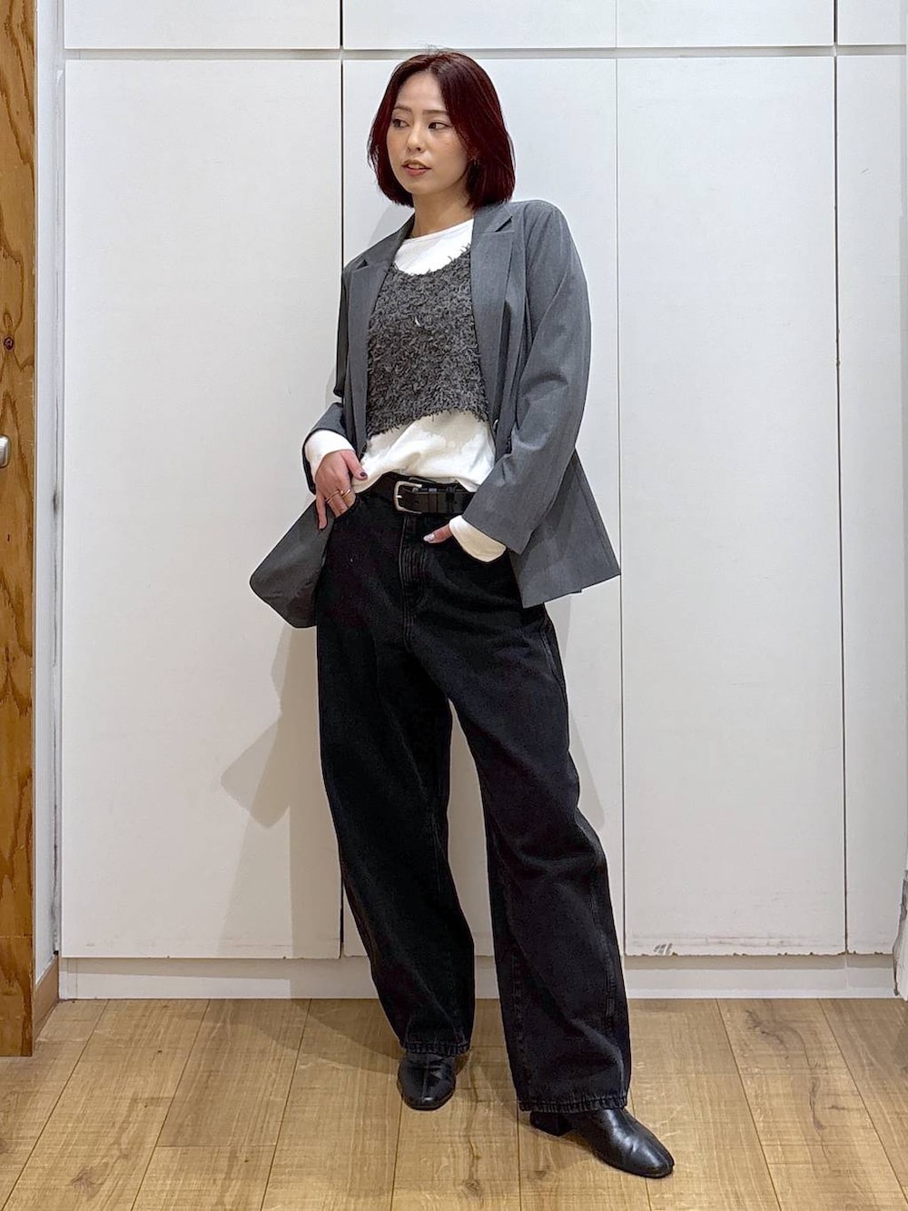 グレー系のテーラードジャケット、ブラック系のブーツ、ブラック系のデニムパンツを着用したレディースの春コーディネートの3枚目の写真