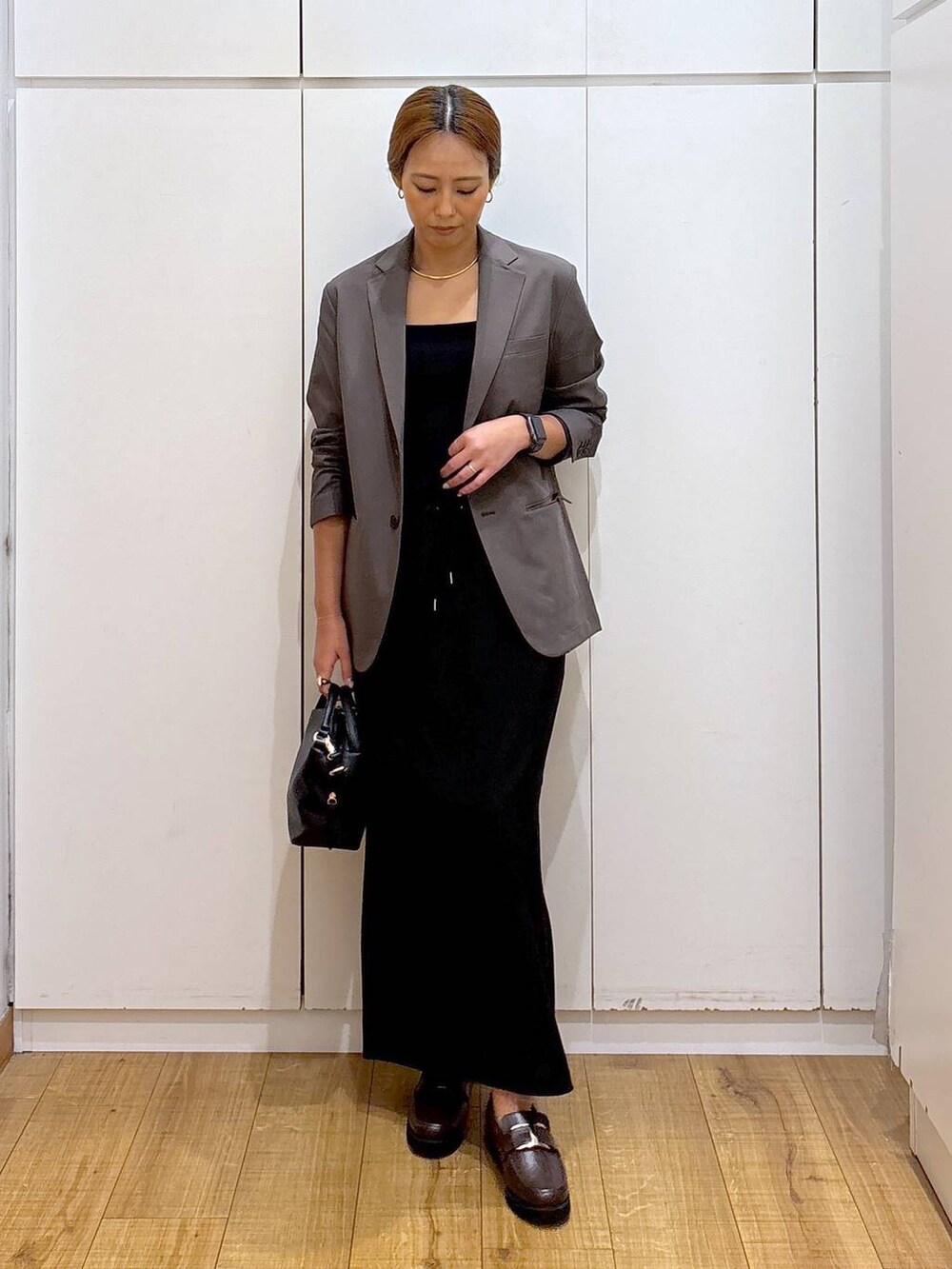 ブラック系のショルダーバッグ、ブラウン系のローファー、ブラック系のキャミソールを着用したレディースの秋コーディネートの3枚目の写真