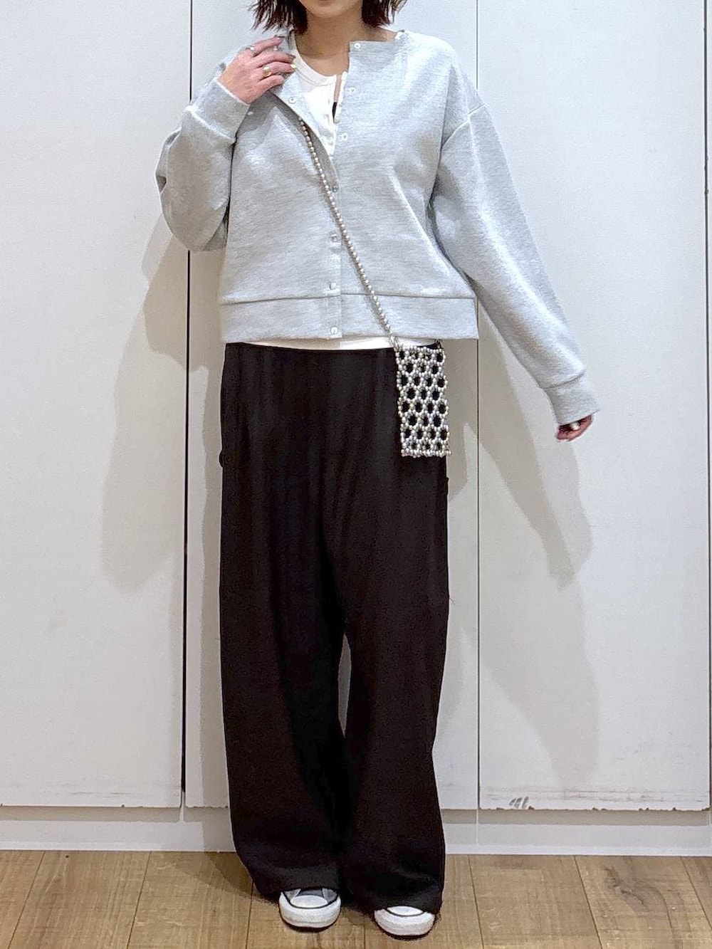 グレー系のカーディガン/ボレロ、ブラウン系のその他パンツ、ホワイト系のタンクトップを着用したレディースの春コーディネートの2枚目の写真