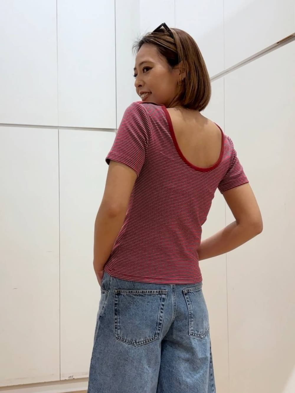 ブルー系のデニムパンツ、レッド系のTシャツ/カットソーを着用したレディースの春コーディネートの4枚目の写真