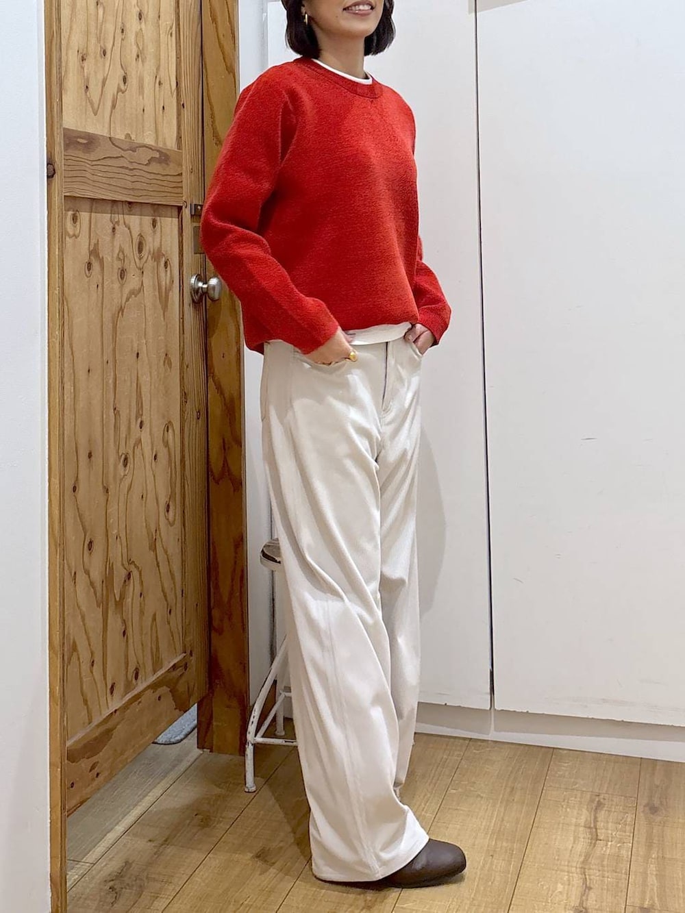 グレー系のその他パンツ、ブラウン系のブーツ、レッド系のニット/セーターを着用したレディースの冬コーディネートの7枚目の写真