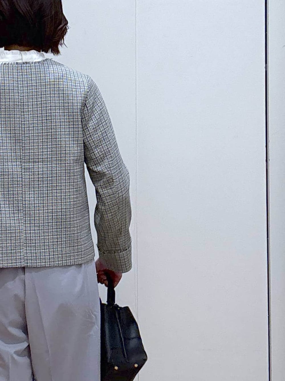 ブラック系のローファー、ブルー系のスラックス、ホワイト系のテーラードジャケットを着用したレディースの冬コーディネートの5枚目の写真