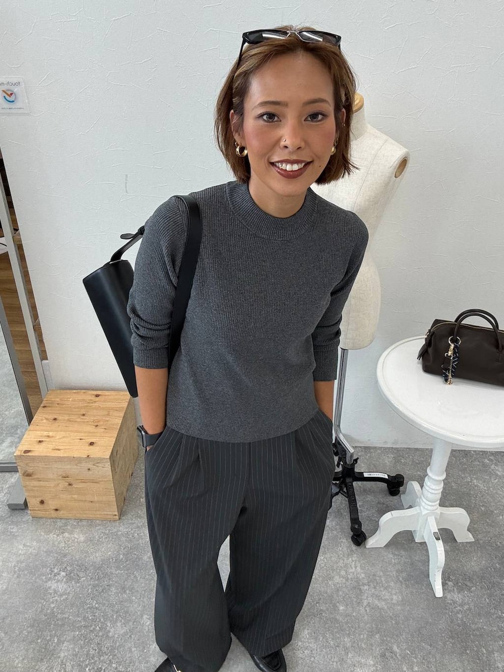 グレー系のその他パンツ、ブラック系のショルダーバッグ、ブラック系のローファーを着用したレディースの秋コーディネートの2枚目の写真
