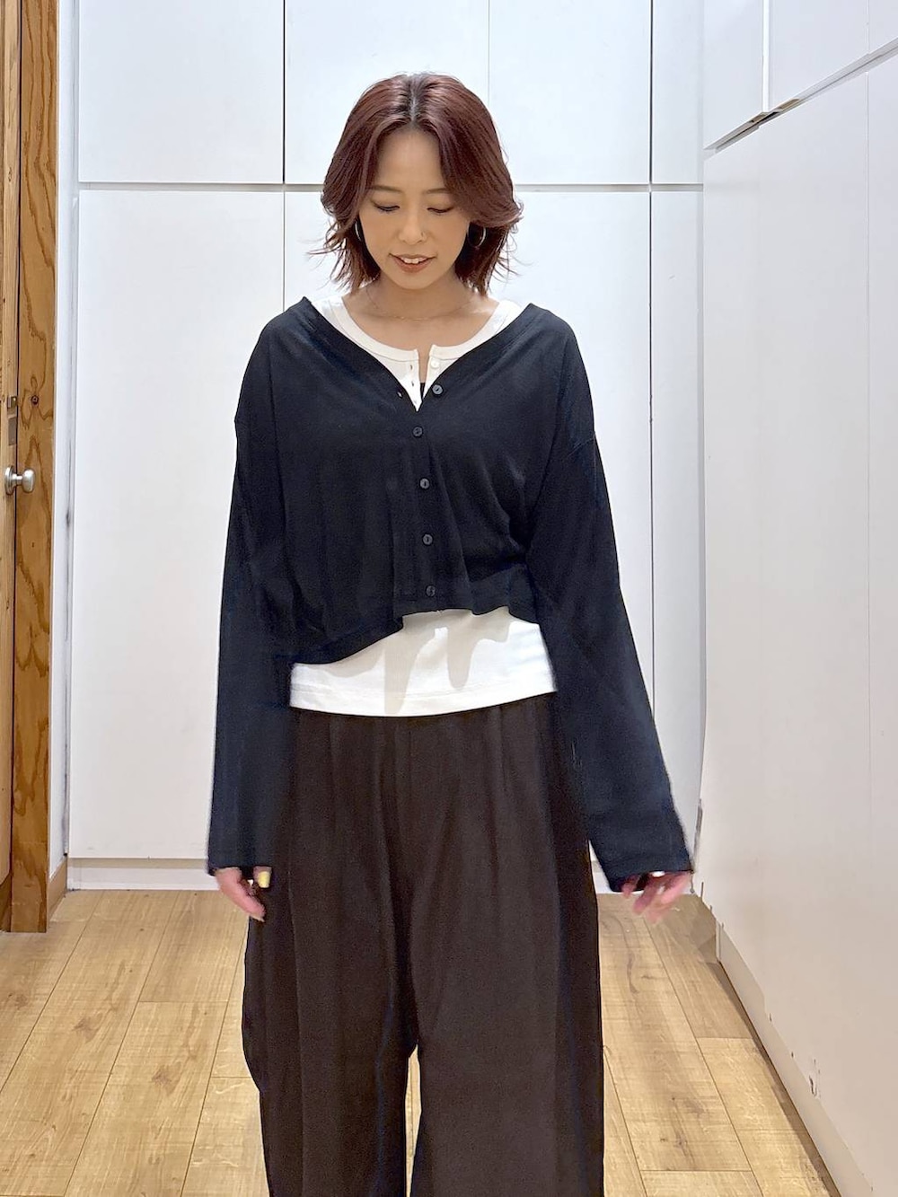 ブラウン系のその他パンツ、ホワイト系のタンクトップ、ブラック系のカーディガン/ボレロを着用したレディースの春コーディネートの7枚目の写真