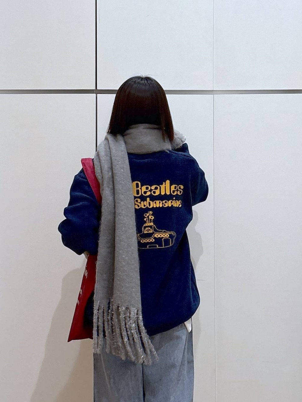 ブルー系のデニムパンツ、ホワイト系のTシャツ/カットソー、レッド系のトートバッグを着用したレディースの冬コーディネートの4枚目の写真