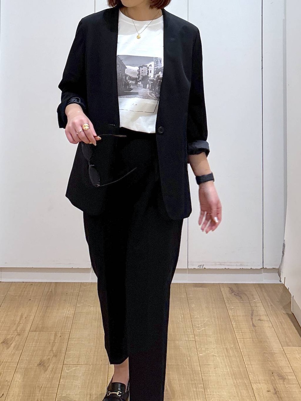 ブラック系のローファー、ブラック系のスラックス、ブラック系のノーカラージャケットを着用したレディースの春コーディネートの5枚目の写真