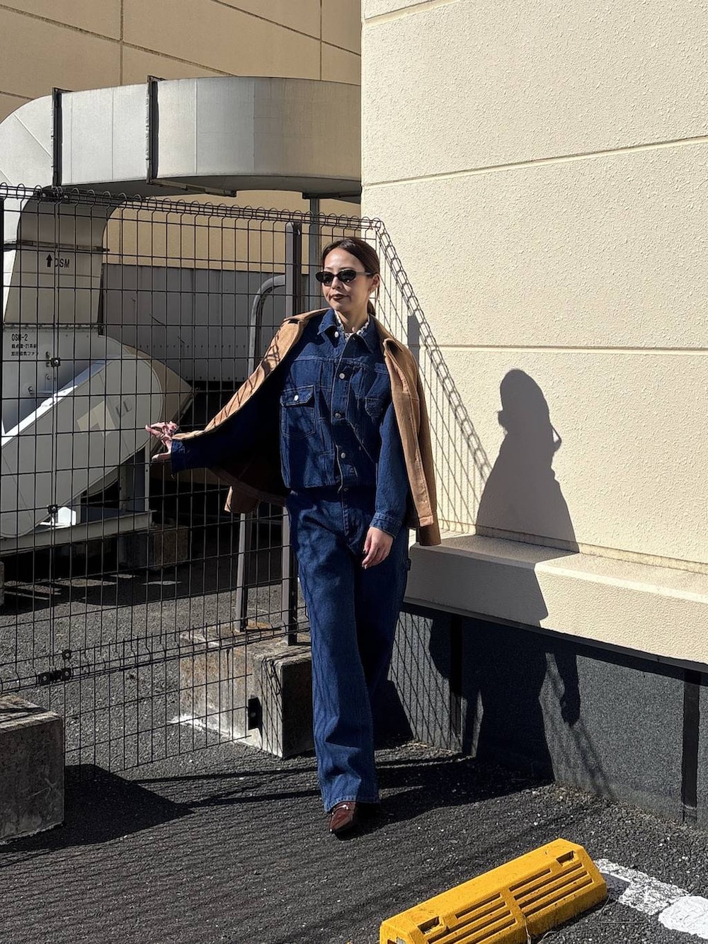 ブルー系のデニムジャケット、ブラウン系のテーラードジャケット、ブルー系のデニムパンツを着用したレディースの冬コーディネートの7枚目の写真