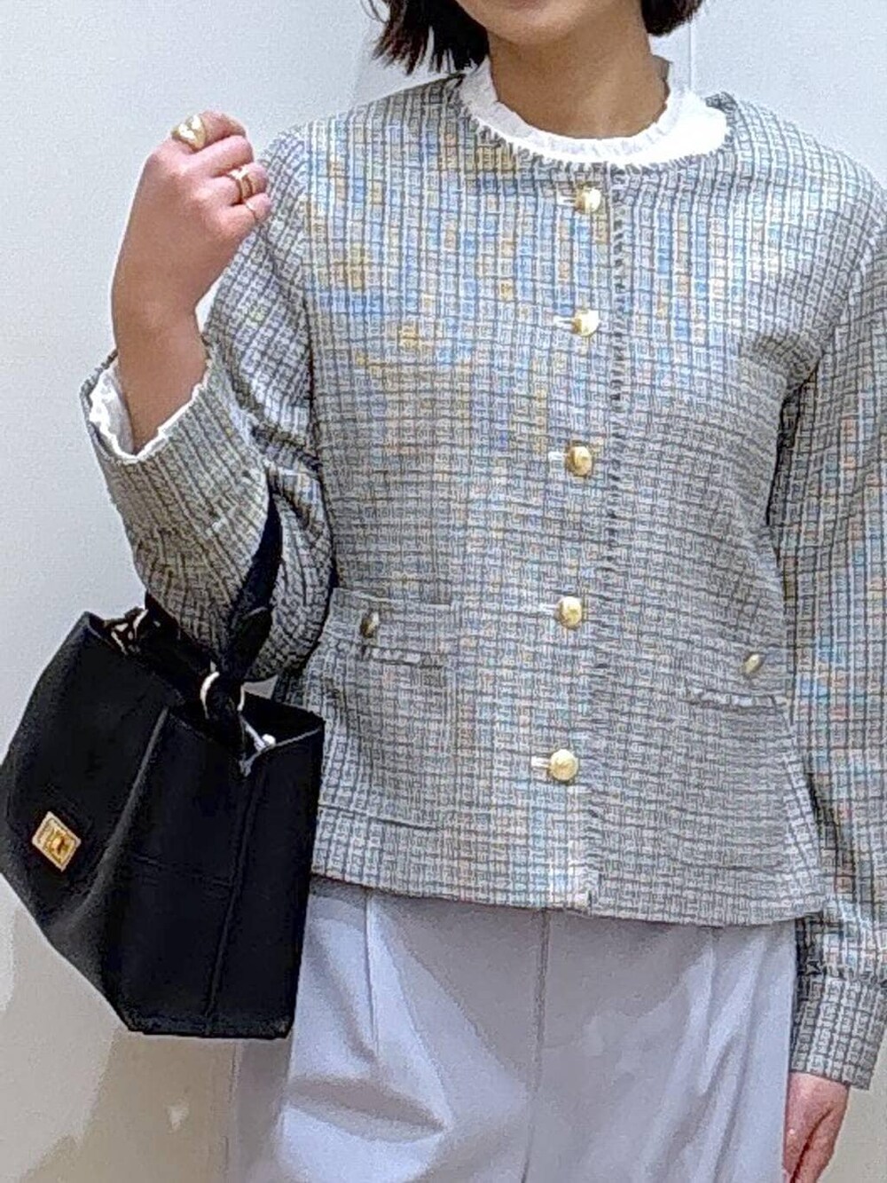 ブラック系のローファー、ブルー系のスラックス、ホワイト系のテーラードジャケットを着用したレディースの冬コーディネートの4枚目の写真