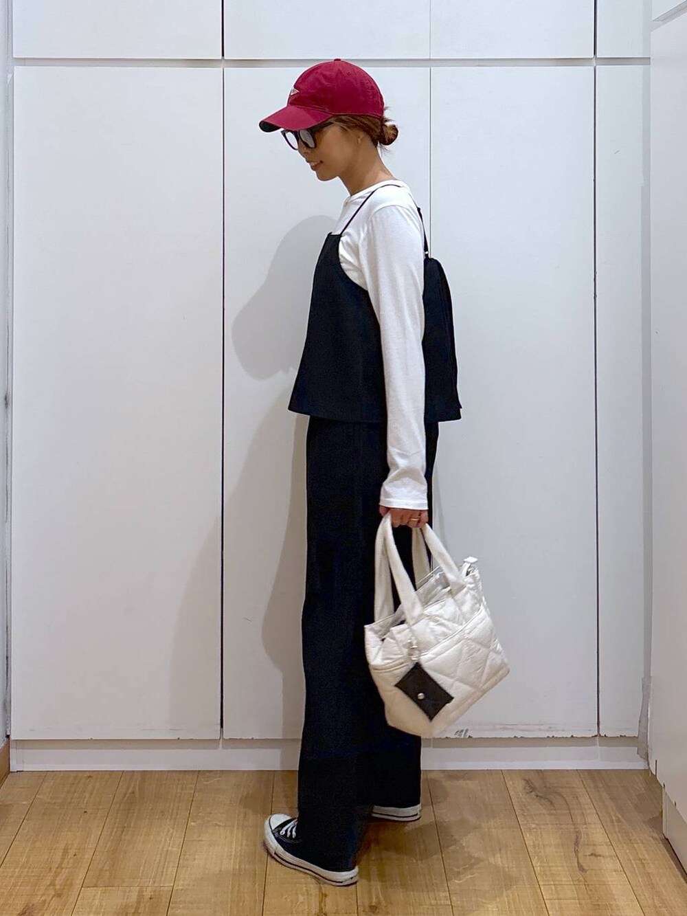 ホワイト系のトートバッグ、ブラック系のサロペット/オーバーオール、ブラック系のサングラスを着用したレディースの秋コーディネートの5枚目の写真