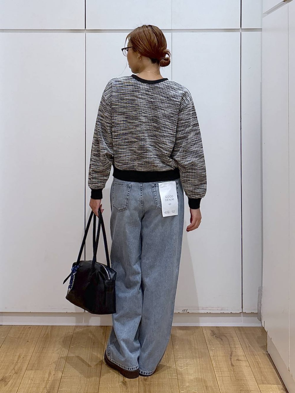 ブラック系のボストンバッグ、ブルー系のデニムパンツ、ベージュ系のローファーを着用したレディースの秋コーディネートの6枚目の写真