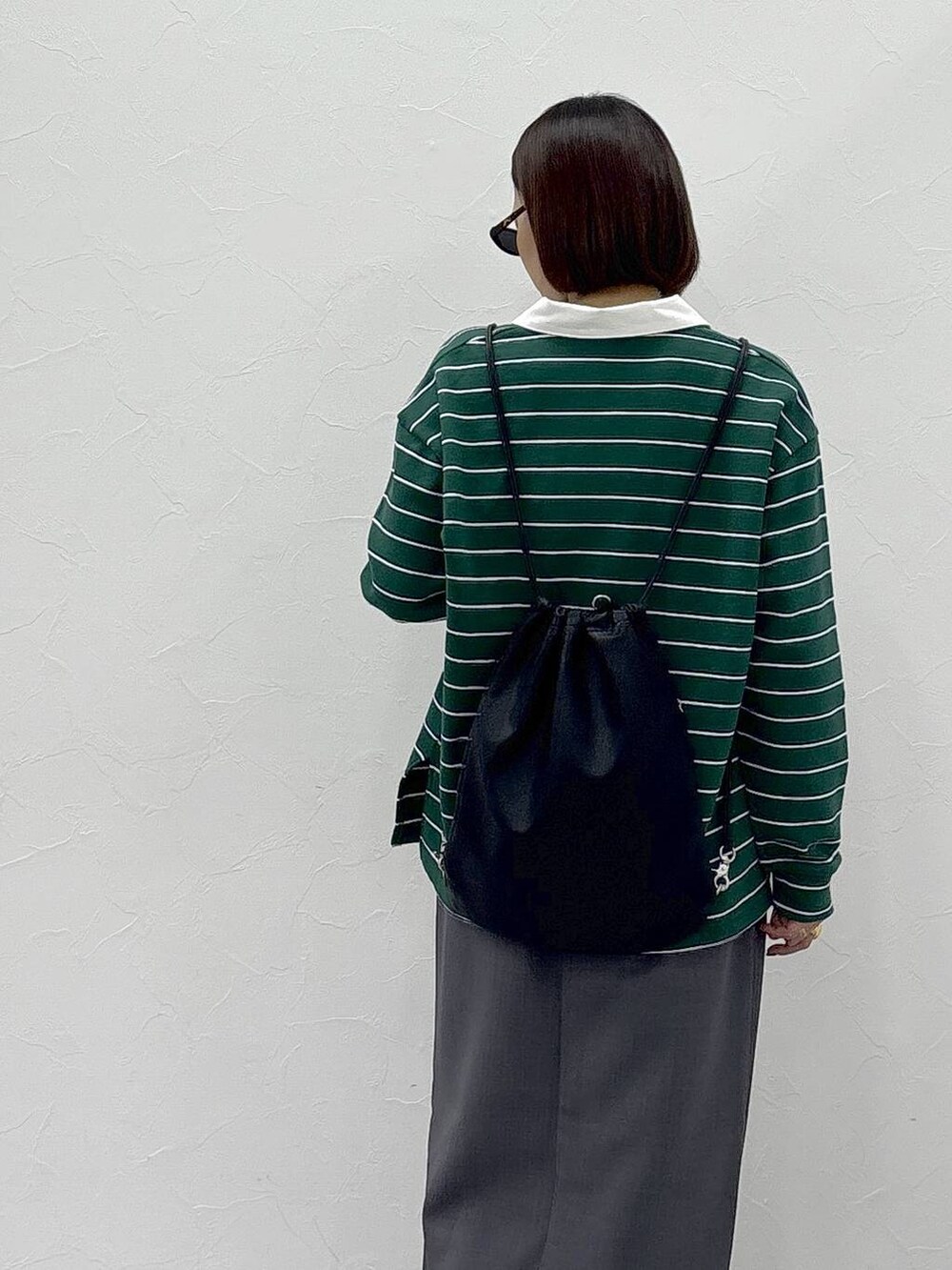 ブラック系のスニーカー、ベージュ系のスカート、グリーン系のスウェットを着用したレディースの冬コーディネートの5枚目の写真