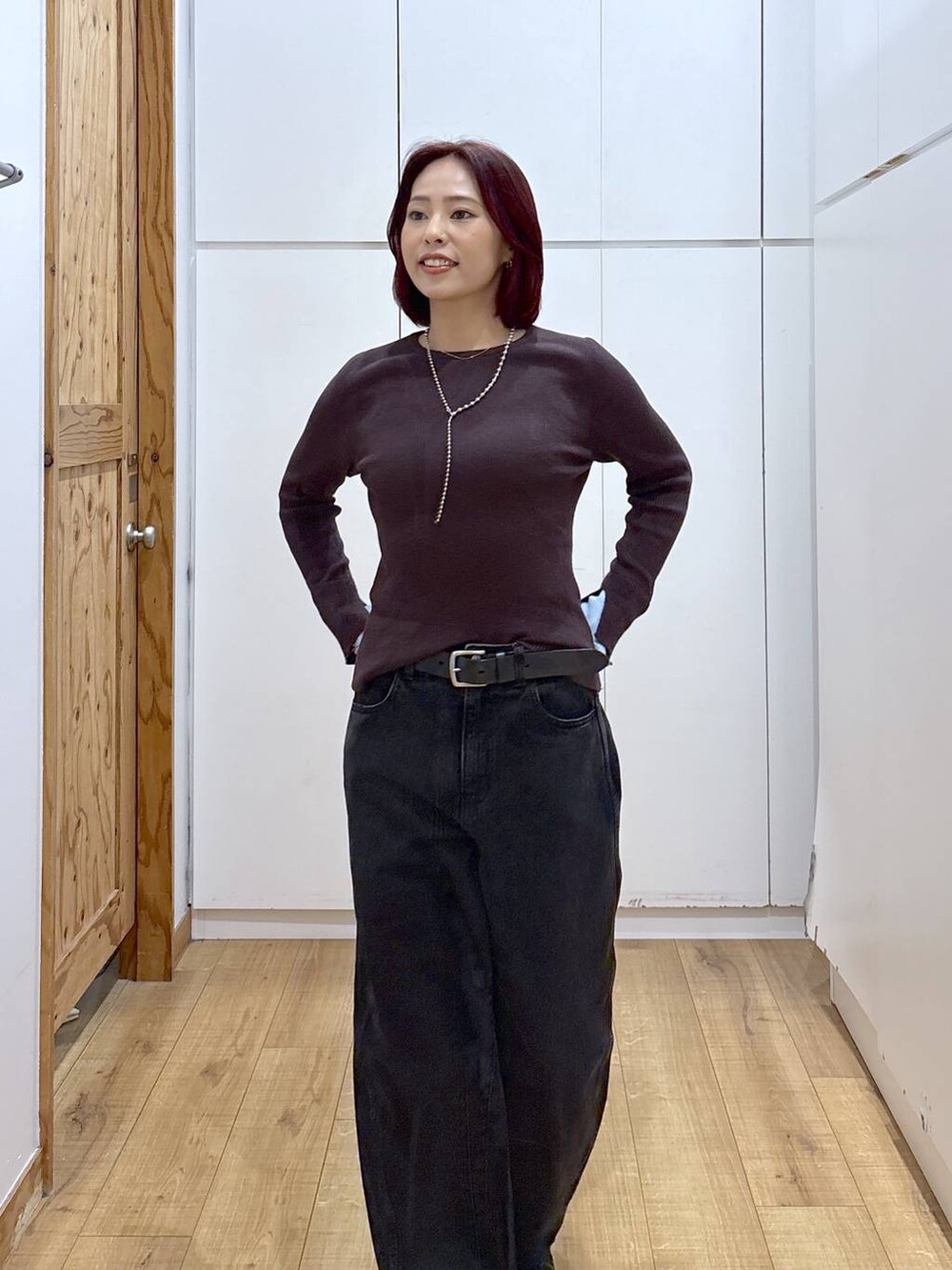 ブラック系のブーツ、ブラック系のデニムパンツ、ブラウン系のニット/セーターを着用したレディースの春コーディネートの5枚目の写真