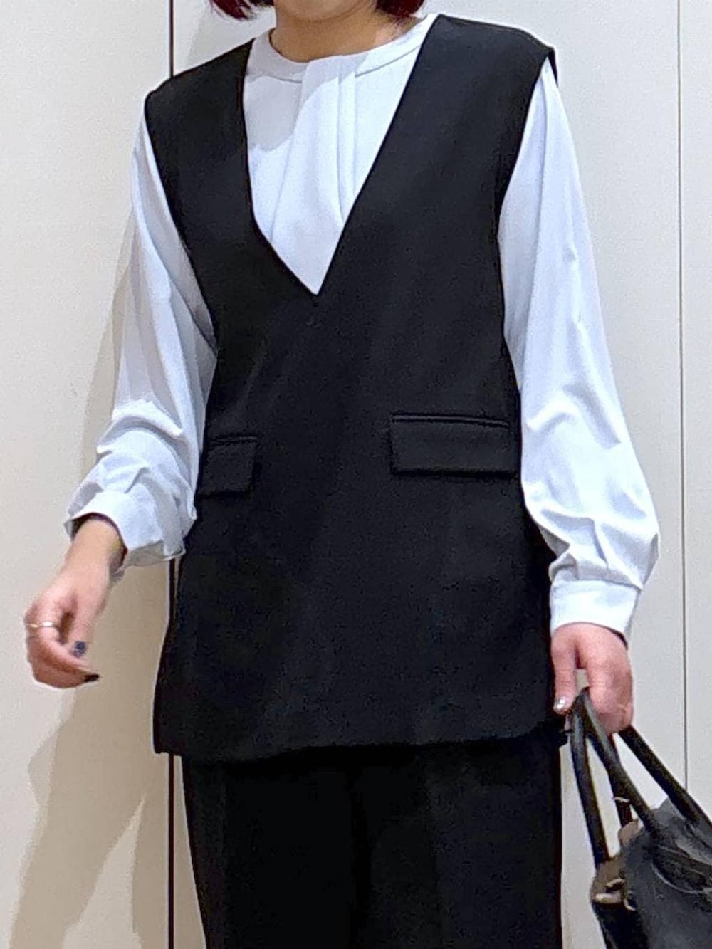 ブラック系のショルダーバッグ、ブラック系のパンプス、ブルー系のシャツ/ブラウスを着用したレディースの春コーディネートの7枚目の写真