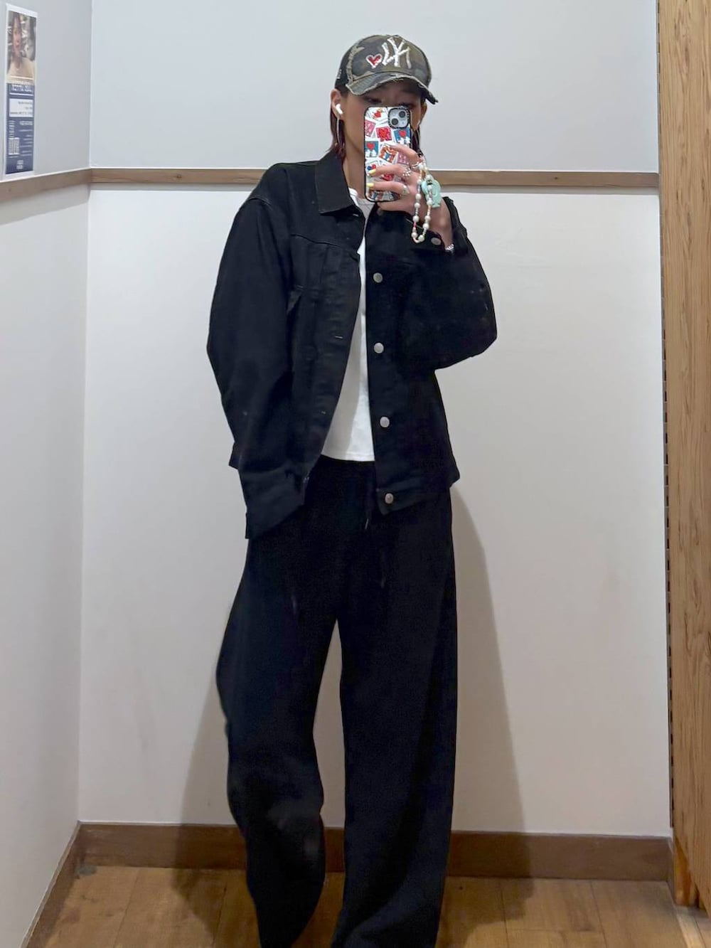 ブラック系のデニムジャケット、ブラック系のスウェットパンツ、ゴールド系のネックレスを着用したレディースの春コーディネートの5枚目の写真