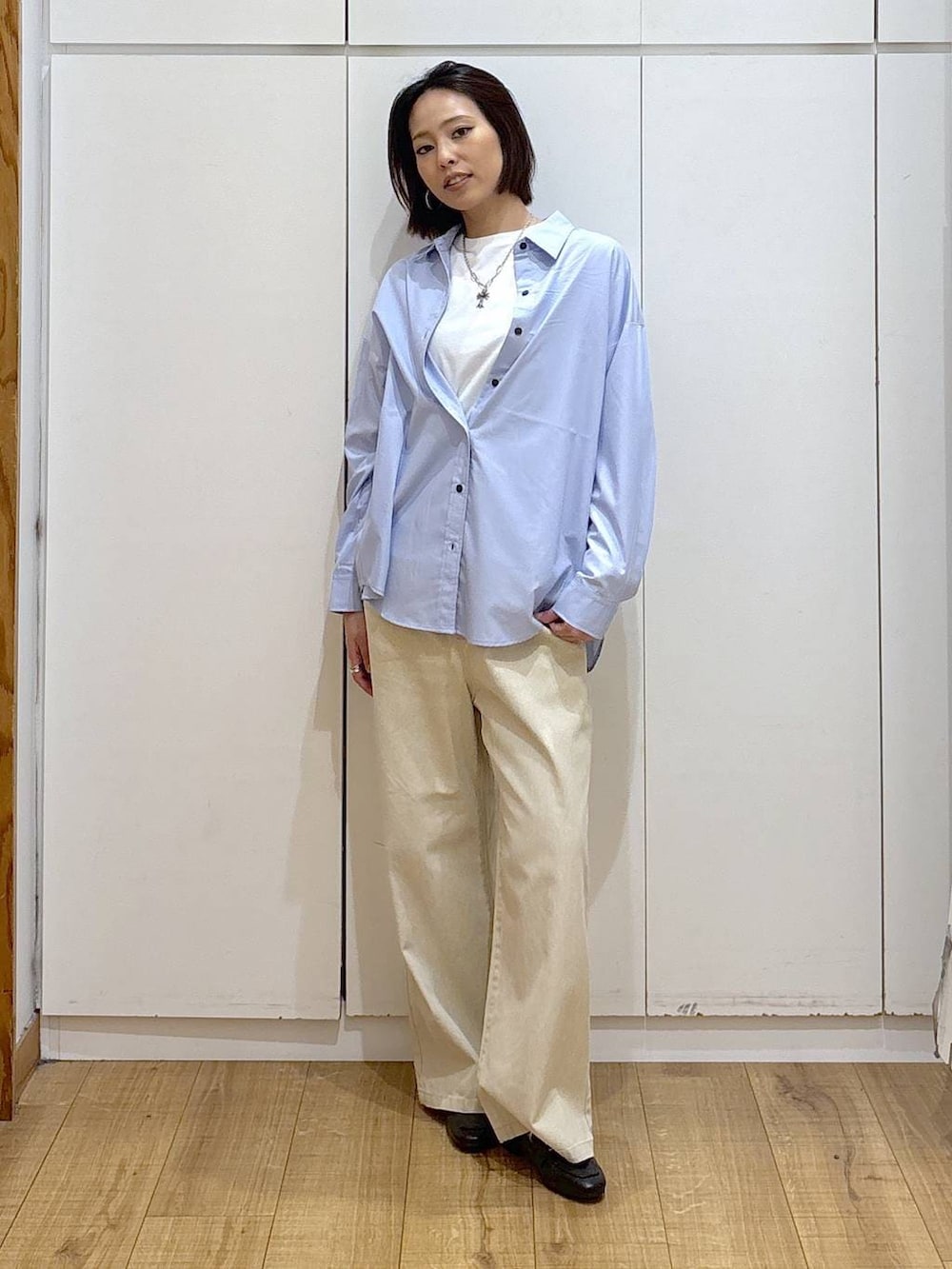 ブラック系のローファー、ブルー系のシャツ/ブラウス、ホワイト系のTシャツ/カットソーを着用したレディースの冬コーディネートの2枚目の写真