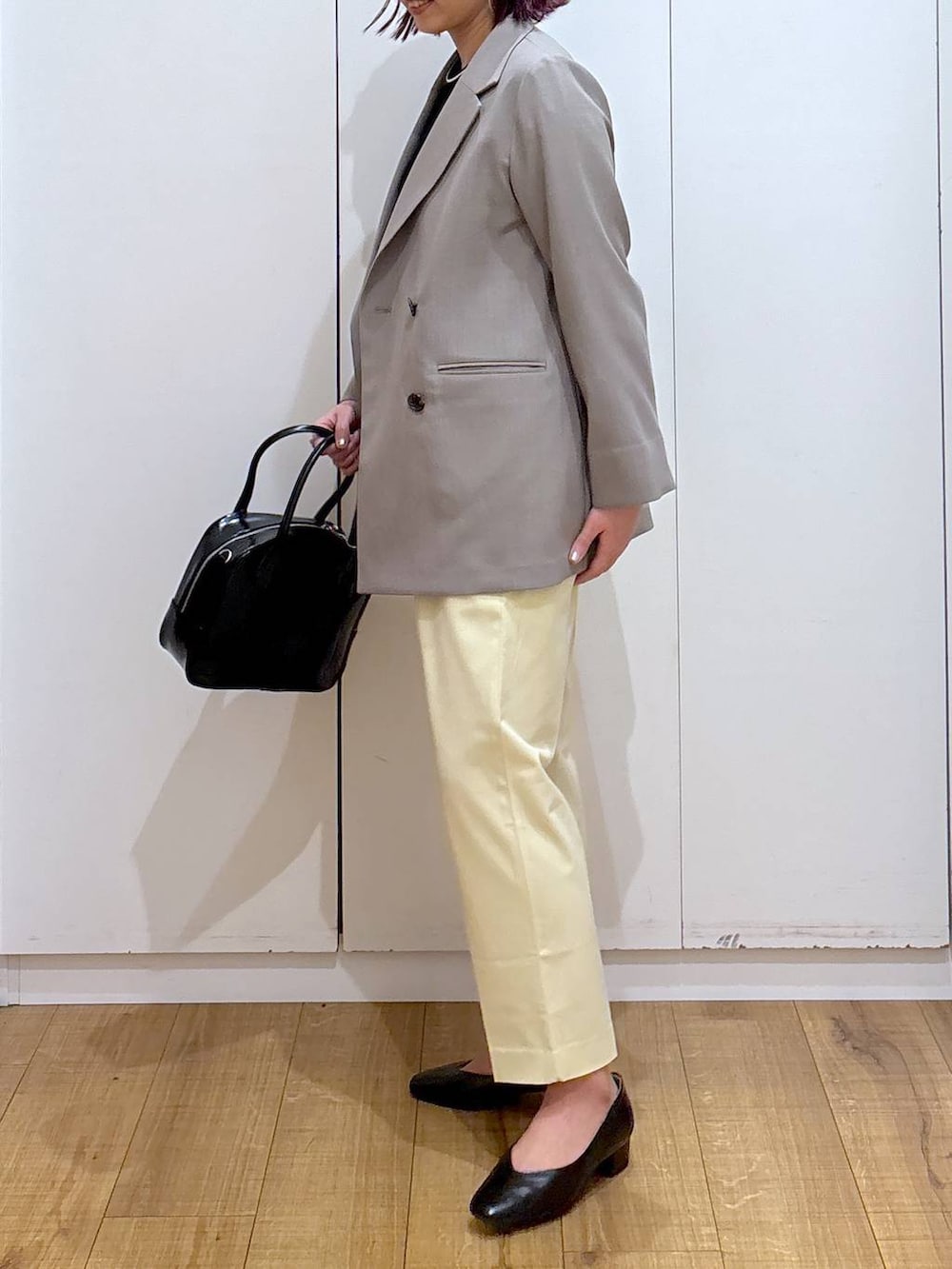 イエロー系のその他パンツ、ブラック系のボストンバッグ、ブラック系のニット/セーターを着用したレディースの春コーディネートの3枚目の写真
