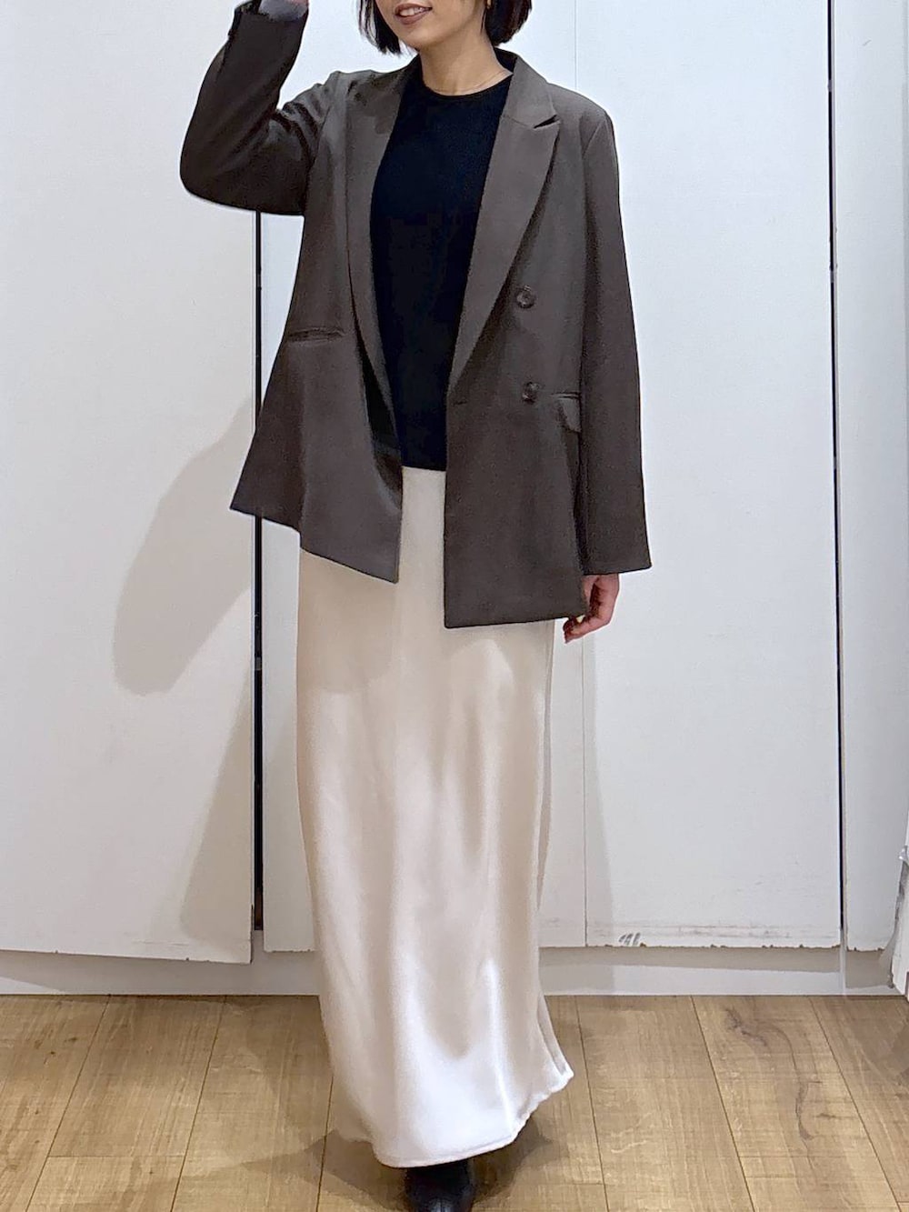 ブラック系のブーツ、ブラウン系のテーラードジャケット、グレー系のスカートを着用したレディースの冬コーディネートの4枚目の写真