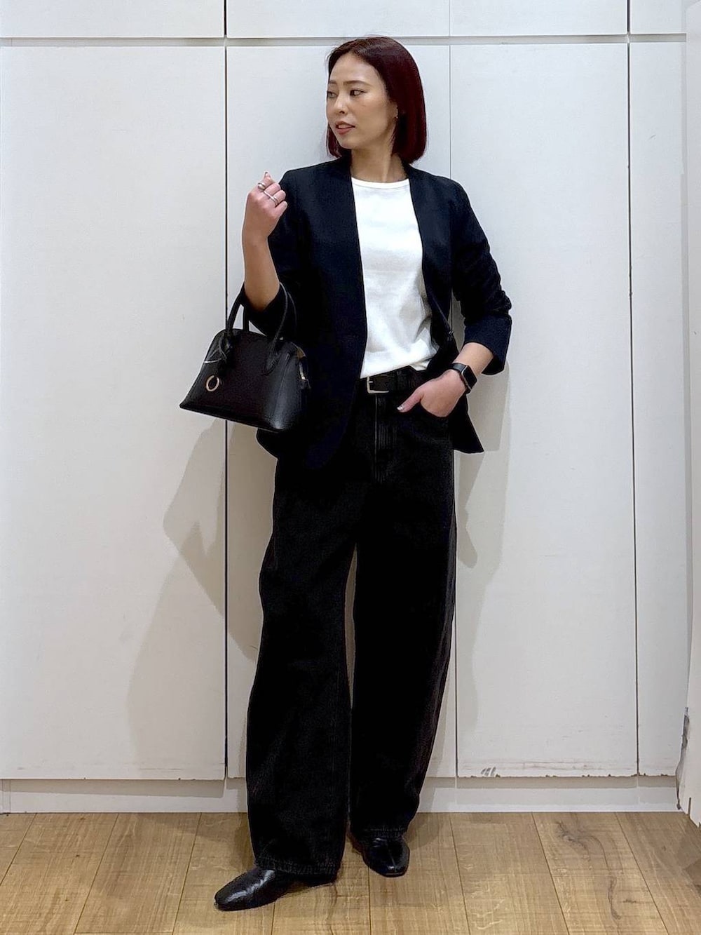 ブラック系のショルダーバッグ、ブラック系のブーツ、ブルー系のノーカラージャケットを着用したレディースの春コーディネートの3枚目の写真