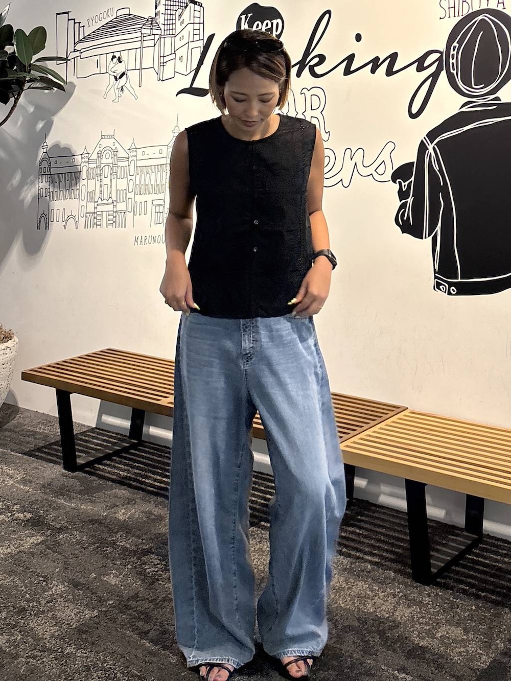 ブラック系のキャミソール、ブルー系のデニムパンツ、ブラック系のベストを着用したレディースの夏コーディネートの5枚目の写真