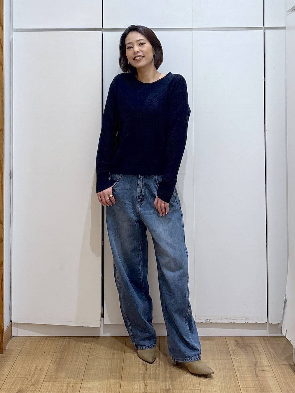 ブルー系のニット/セーター、ベージュ系のブーツ、ブルー系のデニムパンツを着用したレディースの冬コーディネートの3枚目の写真