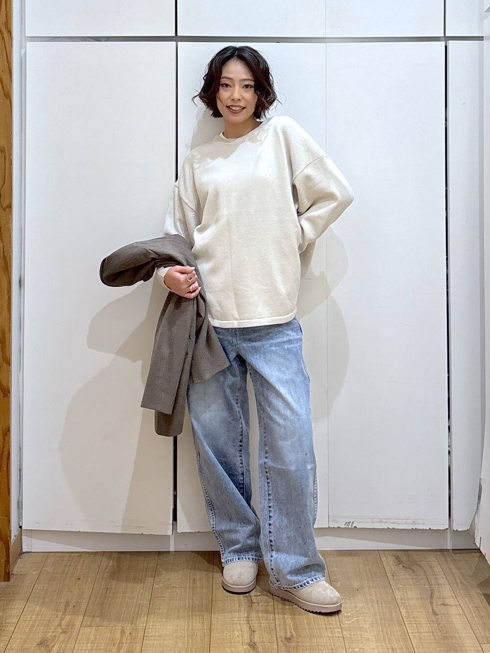 ブラック系のニット/セーター、ブルー系のデニムパンツ、ホワイト系のTシャツ/カットソーを着用したレディースの冬コーディネートの2枚目の写真