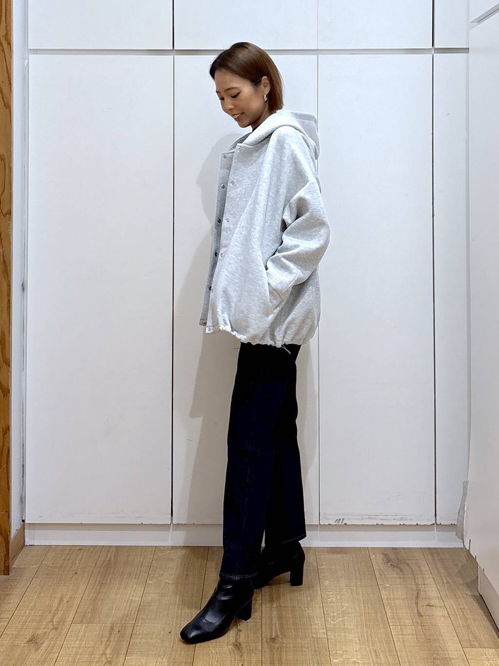 ブルー系のデニムパンツ、ブラック系のニット/セーター、グレー系のブルゾンを着用したレディースの秋コーディネートの6枚目の写真