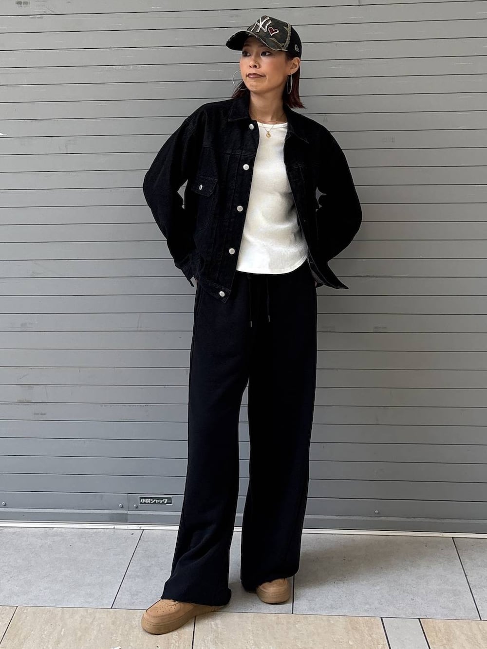 ブラック系のデニムジャケット、ブラック系のスウェットパンツ、ゴールド系のネックレスを着用したレディースの春コーディネートの4枚目の写真