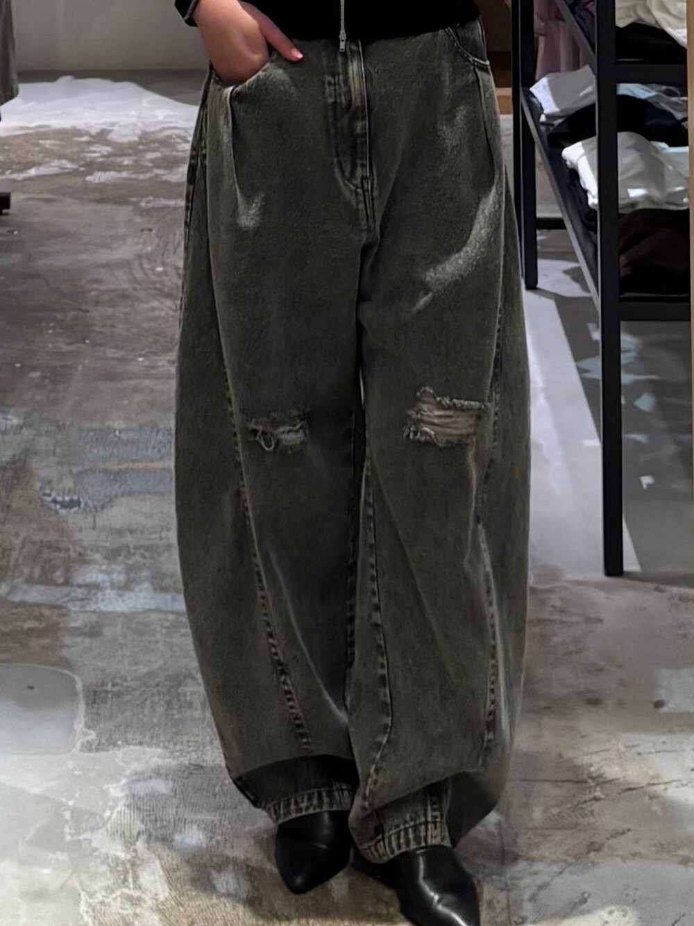 グレー系のデニムパンツ、ブラック系のベストを着用したレディースの春コーディネートの3枚目の写真