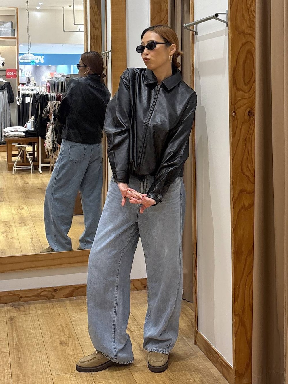 ブラック系のブルゾン、ブルー系のデニムパンツ、ベージュ系のローファーを着用したレディースの秋コーディネートの2枚目の写真